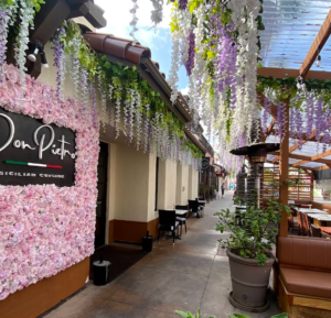 Outdoor restaurant patio with wisteria flowers and string lighting